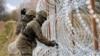 Солдаты строят забор из колючей проволоки на границе Польши с российским Калининградом близ города Больце, Польша, 3 ноября 2022 года