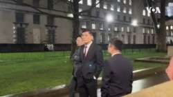 中國駐英公使楊曉光在香港經貿辦新年酒會場外企圖避開示威者