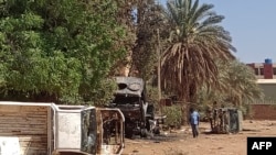 Mwanamume akikagua magari yaliyoharibiwa nje ya makao makuu ya vikosi vya Rapid Support Forces (RSF) huko Khartoum mnamo Aprili 19, 2023. Picha na AFP.