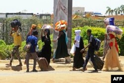 Watu wakikimbia kutoka upande wa kusini ya Sudan Aprili 18, 2023, wakati mapigano kati ya jeshi na wanamgambo yakiendelea kwa siku ya nne. Picha na AFP).