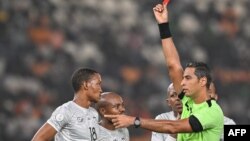 Mwamuzi wa Misri akimwonyesha kadi nyekundu beki wa Afrika Kusini Grant Kekana (kushoto) wakati wa mchezo wa nusu fainali ya Kombe la Mataifa ya Afrika (CAN) 2024 Februari 7,2024. Picha na Issouf SANOGO / AFP