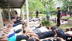 ໃນ​ພາບນີ້​ທີ່​ຖືກ​ເປີດ​ເຜີຍ​ໂດຍ​ເຈົ້າ​ໜ້າ​ທີ່ ອິນ​ໂດ​ເນ​ເຊຍ, ສະ​ແດງ​ໃຫ້​ເຫັນ​ຄົນ​ຕ່າງ​ຊາດ​ຖືກ​ຄວບ​ຄຸມ​ຕົວ​ໃນ​ການ​ກ່າວ​ຫາ ກ່ຽວ​ກັບ ການ​ດຳ​ເນີນ​ອາ​ຊະ​ຍາ​ກຳ​ທາງ​ຄອມ​ພິວ​ເຕີ ແລະ ລະ​ເມີດ​ວີ​ຊາ ນອນ​ຢູ່​ພື້ນ​ດິນ ລຸນຫຼັງ​ການ​ບຸກກວດ​ຄົ້ນ, ເກາະ​ບາຫຼີ, ອິນ​ໂດ​ເນ​ເຊຍ, 26 ມິ​ຖຸ​ນາ 2024.