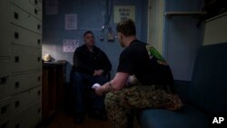 Navy Chaplain Lt. Cmdr. Ben Garrett counsels a sailor in his quarters on the USS Bataan at Norfolk Naval Station in Norfolk, Virginia, March 20, 2023.