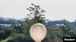 ແຟ້ມຮູບ-ບາລລູນໜ່ວຍນຶ່ງທີ່ເຊື່ອວ່າ ຖືກສົ່ງມາໂດຍ ເກົາຫຼີເໜືອ, ໄດ້ນໍາເອົາຊິ້ນສ່ວນຕ່າງໆລວມທັງອັນທີ່ປາກົດວ່າແມ່ນຂີ້ເຫຍື້ອ ແລະອາຈົມ, ພົບເຫັນ ໃນຂະນະທີ່ມັນຕົກລົງໃນທົ່ງນາຂອງເມືອງເຊວອນ, ເກົາຫຼີໃຕ້, ວັນທີ 29 ພຶດສະພາ 2024. (Yonhap via Reuters) 