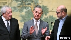 Mahmoud al-Aloul, Vice Chairman of the Central Committee of Palestinian organization and political party Fatah, China's Foreign Minister Wang Yi, and Mussa Abu Marzuk, senior member of Hamas, attend an event in Beijing on July 23, 2024.