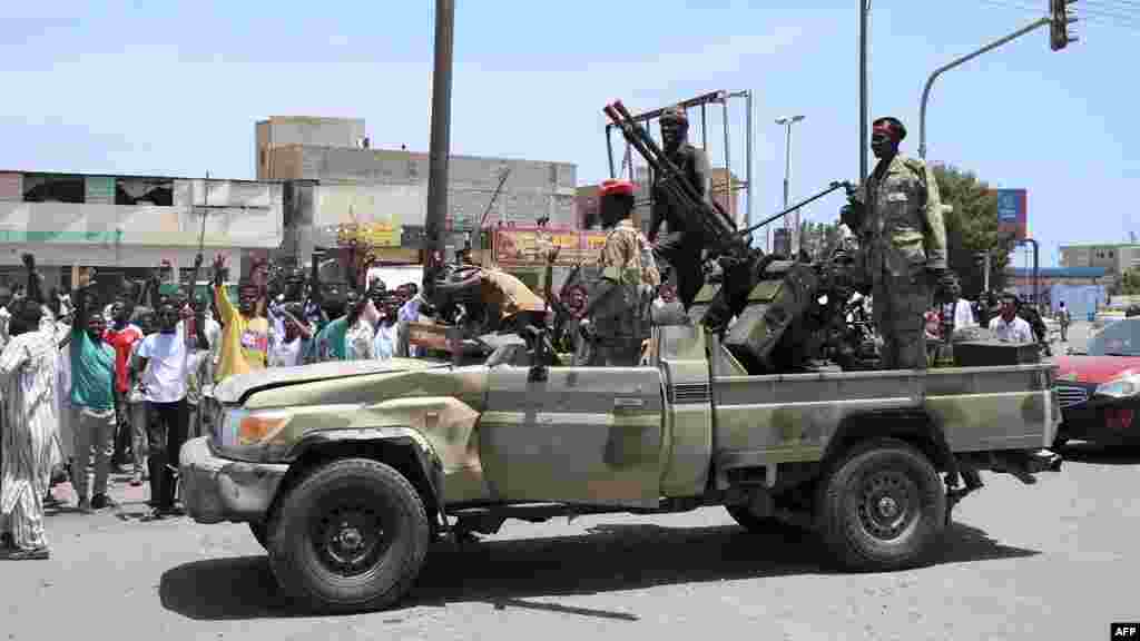 Sudanese greet army soldiers, loyal to army chief Abdel Fattah al-Burhan in the Red Sea city of Port Sudan on April 16, 2023. (AFP) Wasudan wakiwasalimia wanajeshi, ambao wanamuunga mkono Mkuu wa Jeshi Abdel Fattah al-Burhan katika mji wa Red Sea wa Port Sudan Aprili 16, 2023.&nbsp; (AFP)