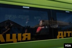 居民麗迪婭坐在巴士內，等待撤離庫皮揚斯克。 (2023年8月19日，美國之音博夏特拍攝)