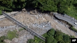This drone shot shows a road damaged by a flash flood in Tanah Datar, West Sumatra, Indonesia, May 12, 2024. Heavy rains and torrents of cold lava and mud flowing down a volcano's slopes on Indonesia's Sumatra island triggered flash floods. 