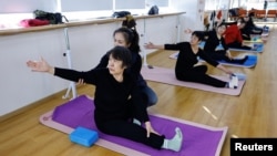 ຄູ​ຄົນ​ນຶ່ງ​ສອນ​ຄົນ​ຊະ​ລາ​ໃນ​ລະ​ຫວ່າງ​ການ​ຮຽນ​ໂຢ​ກາ​ຢູ່ສູນ Mama Sunset, ເຊິ່ງ​ແມ່ນ​ສູນ​ສ​ຳ​ລັບ​ປະ​ຊາ​ຊົນ​ໄວ​ກາງ​ຄົນ ແລະ ອາ​ວຸ​ໂສ​ໃນ​ປັກ​ກິ່ງ, ຈີນ, 15 ມັງ​ກອນ, 2024.