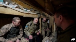 資料照片：一名隨軍神職人員在東正教復活節前夜在哈爾科夫州前線附近的掩體內與烏軍士兵交談。(2023年4月15日)