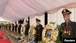 Photos of soldiers who were killed in an ammunition explosion at a military base are displayed during their funeral in Kampong Speu province, Cambodia, April 28, 2024.
