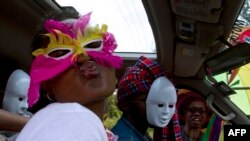 Watu wakiwa wamevaa vinyago kwenye maandamano ya kwanza ya kujivunia mashoga nchini Uganda, Agosti 9, 2014. Picha na ISAAC KASAMANI / AFP.