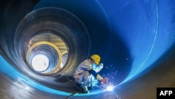 中國江蘇連雲港一家工廠的工人在焊接一個風井。（2023年5月31日）