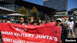 ແຟ້ມພາບ - ຜູ້ຄົນຖືແຜ່ນປ້າຍໃນລະຫວ່າງການຊຸມນຸມຢູ່ສາທາລະນະສຳລັບຊຸມຊົນຊາວມຽນມາຢູ່ໃນອອສເຕຣເລຍ ທີ່ຮຽກຮ້ອງໃຫ້ ASEAN ຢຸດໃຫ້ການສະໜັບສະໜູນແກ່ລັດຖະບານທະຫານມຽນມາ, ຢູ່ດ້ານນອກ ກອງປະຊຸມສຸດຍອດພິເສດຂອງ ASEAN ແລະ ອອສເຕຣເລຍ, ໃນນະຄອນເມລເບີນ, ອອສເຕຣເລຍ, ວັນທີ ມີນາ 2024. 