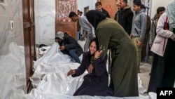 2024年3月5 日，在加沙走廊南部汗尤尼斯的歐洲醫院太平間，巴勒斯坦人在以色列轟炸中喪生的親屬屍體旁哀悼。（法新社照片）