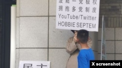 2023年6月22日，網傳北京大學一食堂門外有年輕人舉牌呼喚民主革命和多黨制取代一黨極權。（推特圖片）