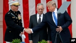 川普總統在阿靈頓公墓圓形劇場發表講話。他與參聯會主席鄧福德上將握手，中間站立者是國防部長馬蒂斯 （2017年5月29日）