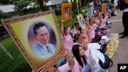 泰国民众手举普密蓬国王的画像在他接受治疗的医院外为国王祈福。（2016年10月12日）