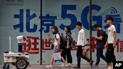 人們在北京街頭一個購物區的5G網絡廣告前走過。 （2019年5月15日）