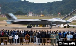8月11號在第14屆珠海航空航天展覽會上，中國製造的殲-20重型隱身戰鬥機停在跑道上供參觀者拍照。照片由美聯社獲自中國的新華社。