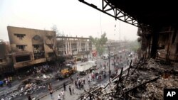 在卡拉達區的爆炸事件後，伊拉克安全部隊和平民聚集在現場