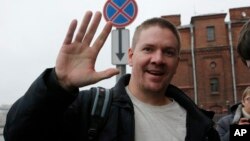 一名英國的綠色和平活動人士安東尼·佩雷特獲釋放後向媒體揮手.
