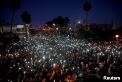 美国加州曼哈顿海滩市的人们悼念在拉斯维加斯城 “91号公路丰收节” 美国乡村音乐会上遭到枪击的遇难者、该市居民拉希尔·帕克和桑迪·凯西（2017年10月4日）。