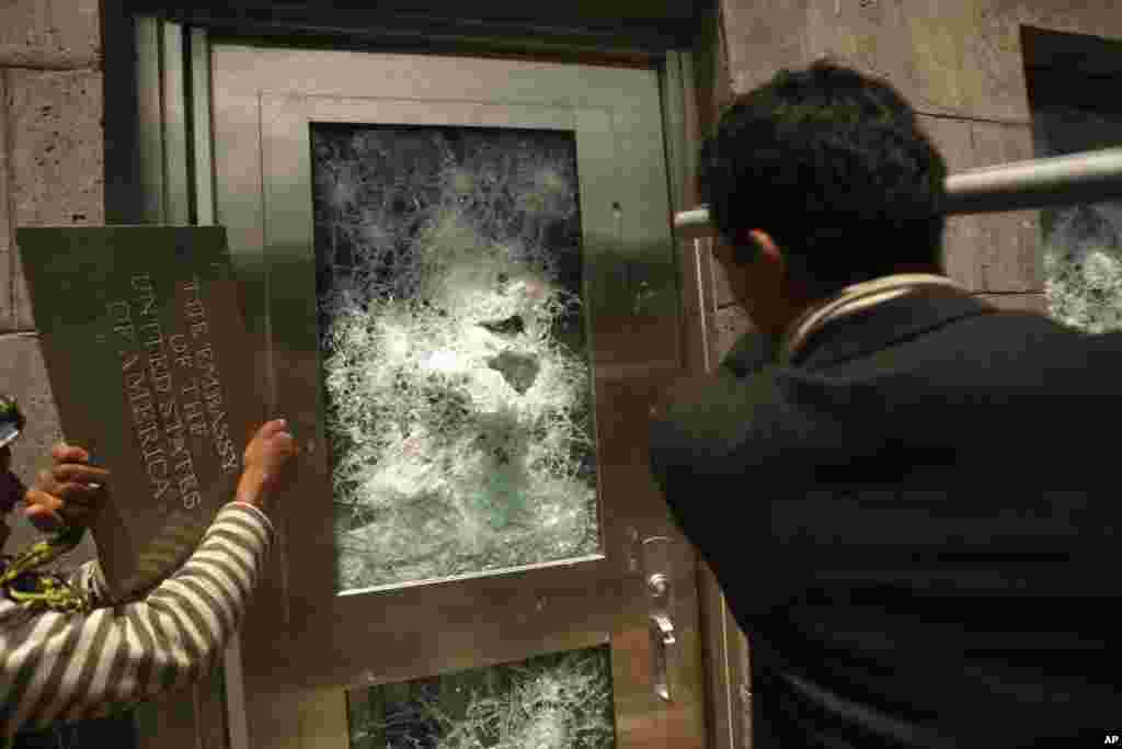 2012年9月13日在也门首都萨那抗议人群冲向美国大使馆的门，抗议美国短片嘲讽伊斯兰先知穆罕默德。