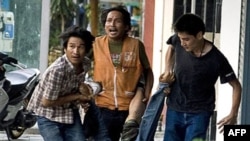 红衫军抗议者抬着一位被枪弹击中的平民