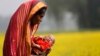 Monowara holds her 22-day-old grandson Arafat, as she walks through a mustard field on the outskirts of Dhaka, Bangladesh, Jan. 22, 2014.