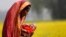 Monowara holds her 22-day-old grandson Arafat, as she walks through a mustard field on the outskirts of Dhaka, Bangladesh, Jan. 22, 2014.