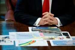 FILE - President Donald Trump talks with reporters after receiving a briefing on Hurricane Dorian in the Oval Office of the White House, Sept. 4, 2019.