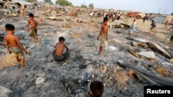 2016年5月3日，在緬甸西部實兌附近的諾開邦，大火摧毀了流離失所的羅欣亞穆斯林的臨時住所，一群男童正在燒毀的住房廢墟中尋找有用物品。