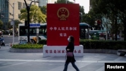 一名女子走過上海街頭宣傳中國憲法的宣傳牌。（2021年11月12日）