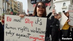 Wanachama wa mashirika ya kutetea haki za binadamu wakiwa wamebeba mabango wakati wa maandamano, baada ya Rais Kais Saied wa Tunisia kuamuru vikosi vya usalama kuzuia uhamiaji haramu na kuwafukuza wahamiaji wote wasio na vibali, huko Tunis, Tunisia Februari 25, 2023.REUTERS