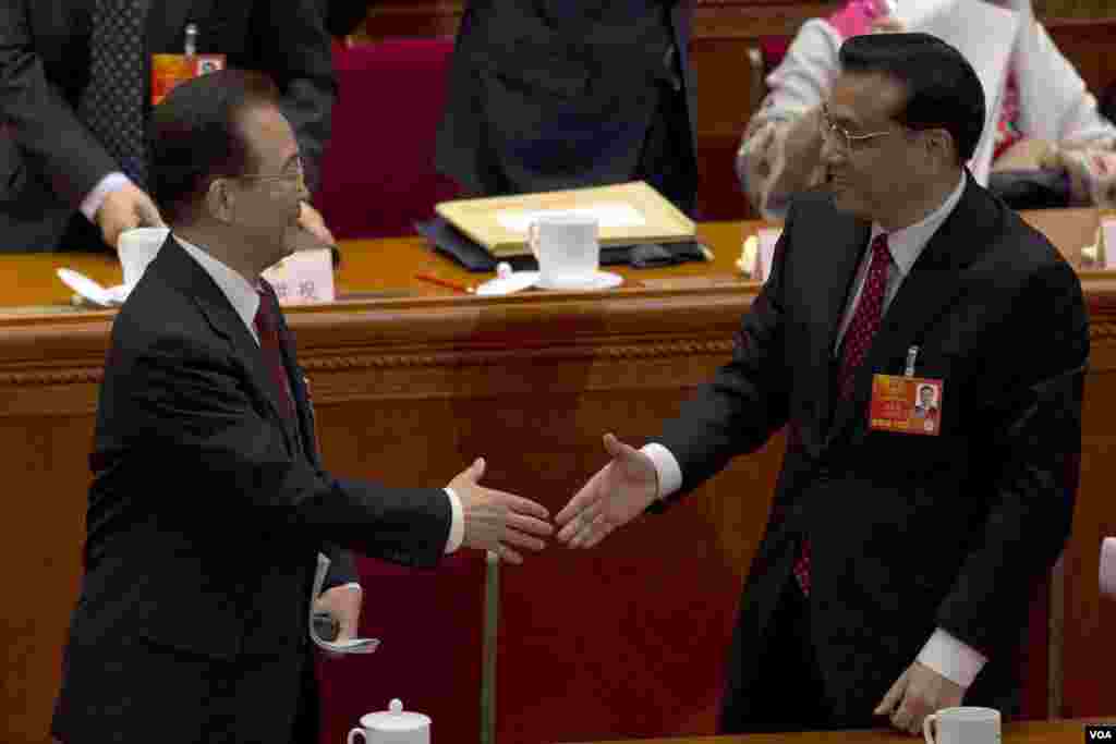 即將離任的中國總理溫家寶2013年3月5日在第十二屆人大開幕式上和預計他的繼任者副總理李克強握手。