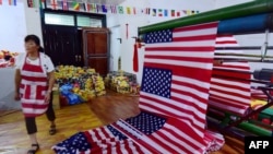 一名中國工人在安徽阜陽的一個製作美國國旗的車間走過。（2018年7月13日）