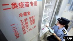 2018年7月23日，當地市場監管機構官員在中國廣西榮安一家醫院檢查疫苗。