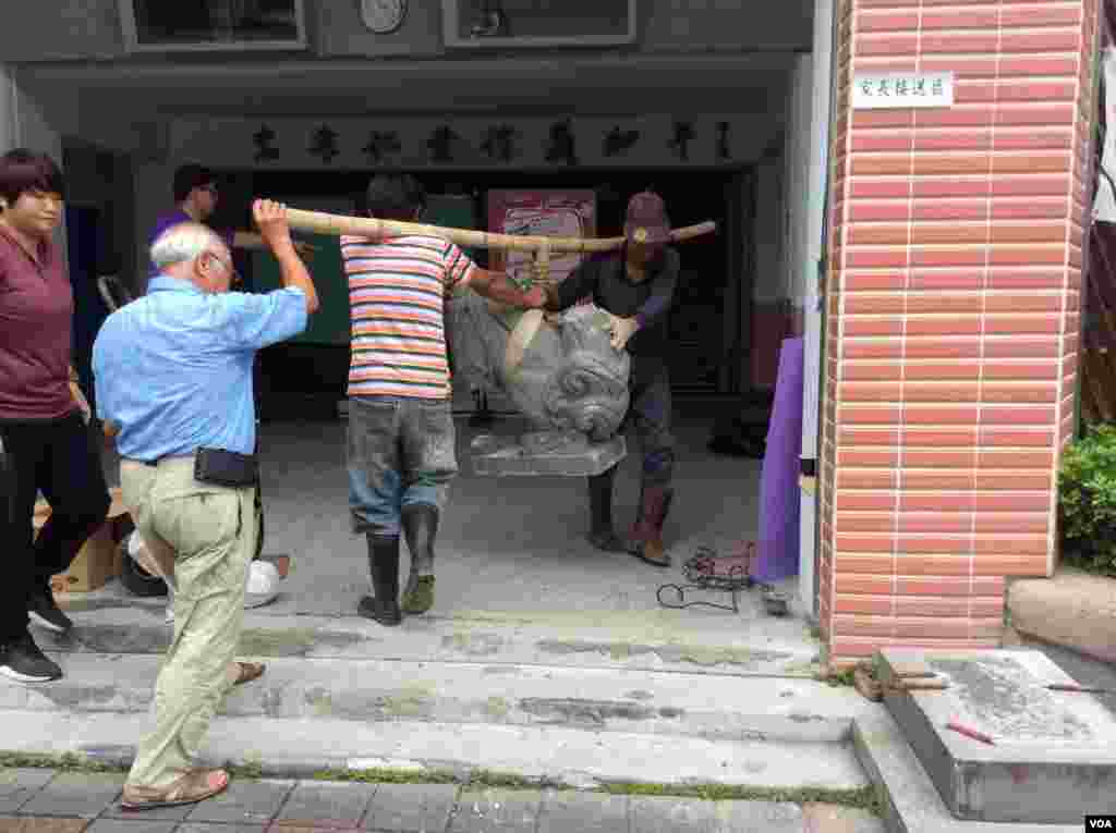 2017年5月30日，石匠正在将新北投逸仙小学门口被破坏石像抬进楼内（美国之音记者申华 拍摄）
