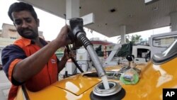 印度一名工人去年正為汽車加油(資料照片)
