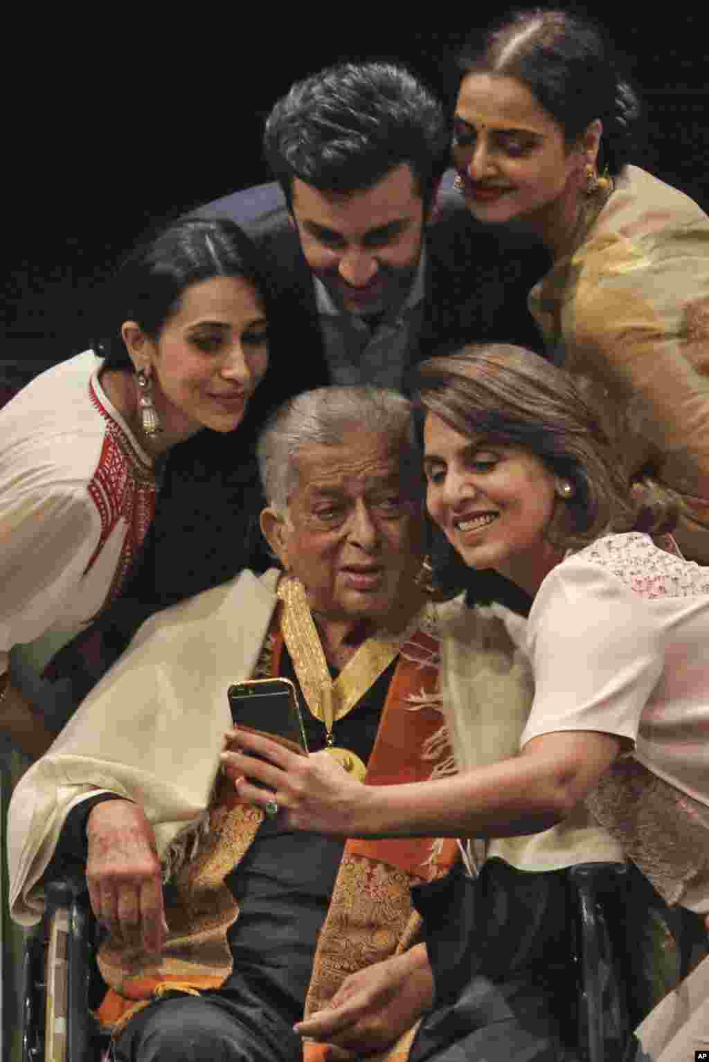 Shahararrun jarumai na Bollywood, daga hagu, Karisma Kapoor, Ranbir Kapoor, Rekha da Neetu Singh su na daukar hoto da shahararren dan fim Shashi Kapoor, wanda ke zaune a kujera, a wurin bukin da aka ba shi lambar yabo mafi girma a harkar fim ta Indiya, &quot;Dadasaheb Phalke Award&quot; ranar 10 Mayu 2015 a Mumbai.(AP Photo)