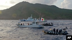 日本海上保安廳船隻與一艘懸掛日本國旗的日本活動人士駕駛的漁船在尖閣諸島附近（中國稱為釣魚島）。 （資料照：2013年8月18日））
