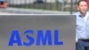 资料照：一名员工走过世界最大半导体制造机器供应商、位于费尔德霍芬的荷兰阿斯麦公司（ASML）总部的标识。（2018 年4月17日）
