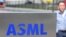 资料照：一名员工走过世界最大半导体制造机器供应商、位于费尔德霍芬的荷兰阿斯麦公司（ASML）总部的标识。（2018 年4月17日）