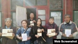 訪民在趙紫陽故居房間外手握紀念卡合影（博訊圖片）