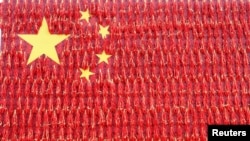 2018年9月21日，在中国河南省孟津县一个村庄，一名男子在用红辣椒组成的一面巨型中国国旗前摆姿势拍照。