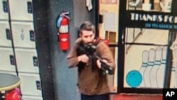 ໃນຮູບທີ່ຖ່າຍຈາກວີດີໂອ ທີ່ເຜີຍແຜ່ອອກມາໂດຍຫ້ອງການຕໍາຫຼວດຂົງເຂດ Androscoggin, ມືປືນຊາຍ ໄດ້ເຂົ້າໄປໃນສະຖານທີ່ພັກຜ່ອນ Sparetime ໃນເມືອງລີວິສຕັນ, ລັດເມນ, ວັນທີ 25 ຕຸລາ 2023. ທ້າວໂຣເບີດ ຄາດ ອາຍຸ 40 ປີ, ຖືກລະບຸໂຕໂດຍຕໍາຫຼວດວ່າ ເປັນບຸກຄົນທີ່ມີຄວາມຕ້ອງການ ແລະກໍາລັງຖືກຊອກຫາໂດຍຕໍາຫຼວດ