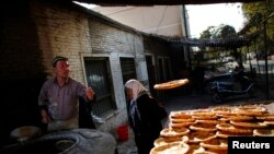 吐鲁番当地市场一位烤馕的维吾尔族男士。