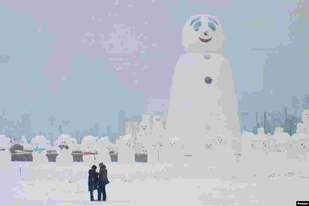 中国哈尔滨的大小雪人和游客（2018年1月8日）