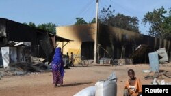 wata mata zaune a gefen hanya da kayanta a bayan da 'yan bindigar Boko Haram suka kai farmaki kan garin Benisheik, September 19, 2013. 